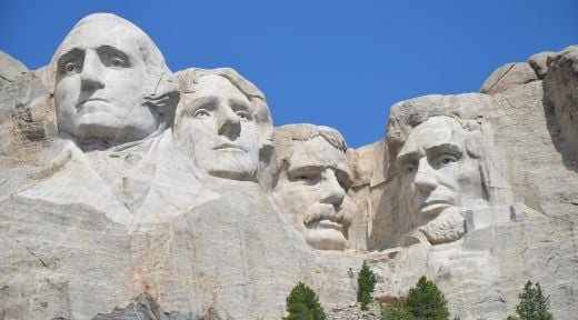 Mount Rushmore: faces of presidents George Washington, Thomas Jefferson, Theodore Roosevelt, and Abraham Lincoln carved into the side of a mountain
